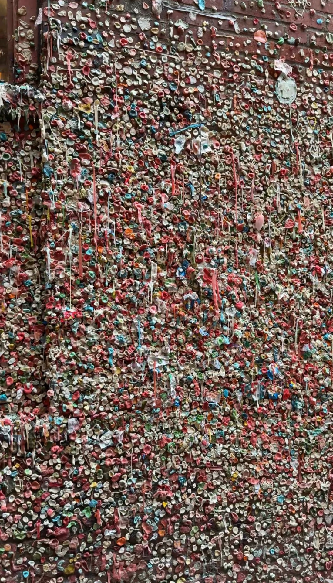 The colorful Gum Wall in Post Alley by Pike Place Market in Seattle, covered in layers of chewed gum