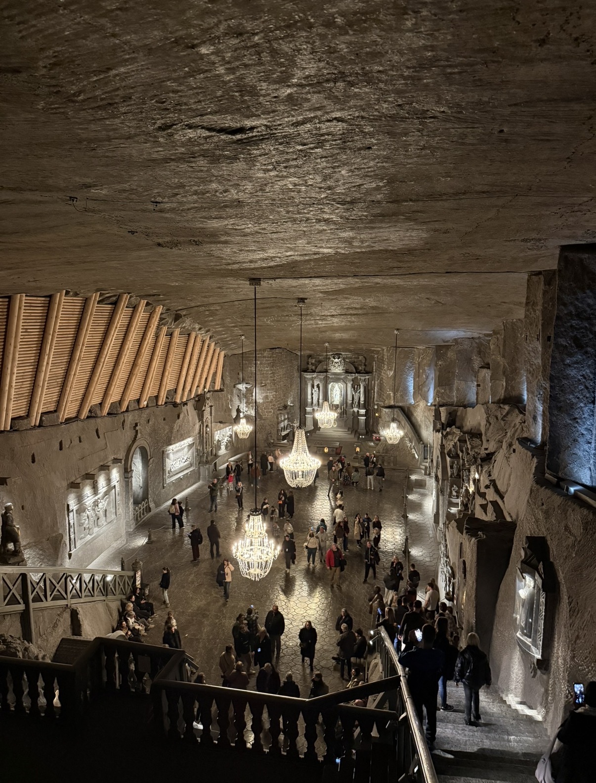 Underground chapel carved from salt in the Wieliczka Salt Mine, with salt-crystal chandeliers, carved reliefs and visitors