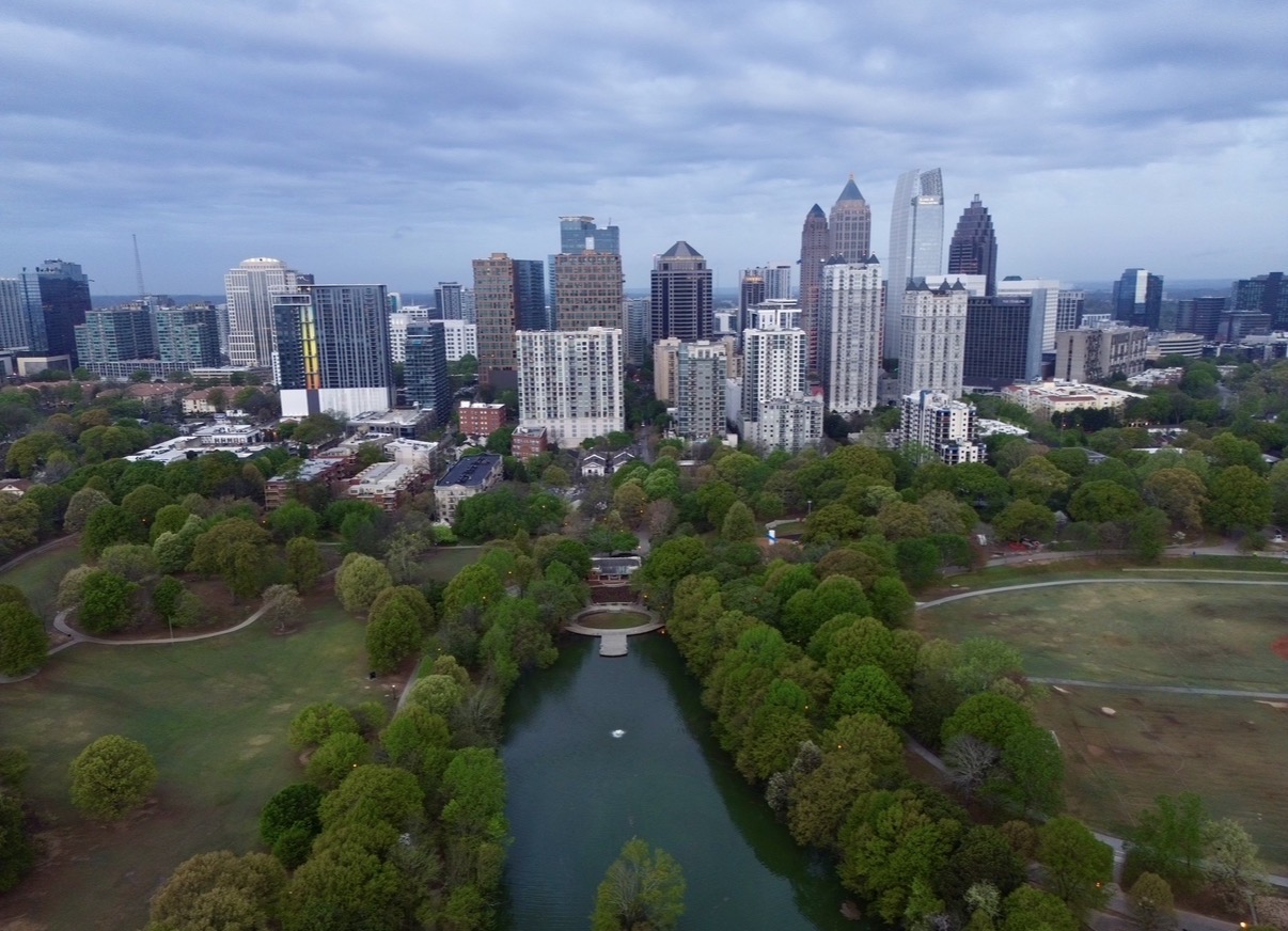 Aerial view of Piedmont Park and Lake Clara Meer with the Midtown Atlanta skyline behind it